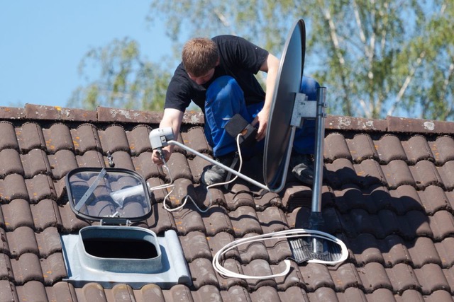 Technicien de Connect System's en intervention sur le toit d'un bâtiment pour l'installation d'une antenne.